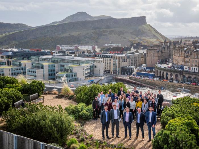 Une image d’employés de Forrit sur un jardin sur le toit avec Arthurs Seat à Édimbourg en arrière-plan.